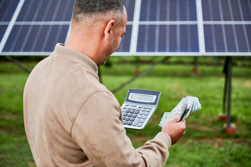 Homeowner calculating energy savings from solar panels in Massachusetts