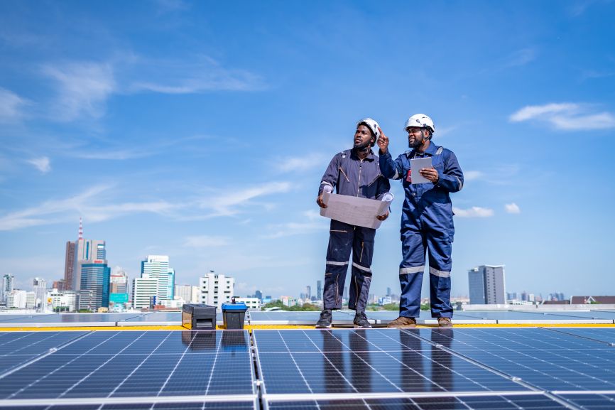 Professional solar installers assessing rooftop solar panel setup in Massachusetts