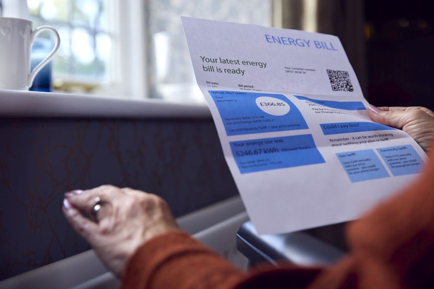 Senior woman reviewing high electricity bill before switching to solar in Massachusetts