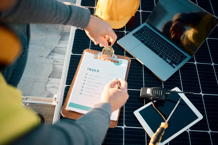 Solar installation technician preparing a checklist on rooftop solar panels in Massachusetts