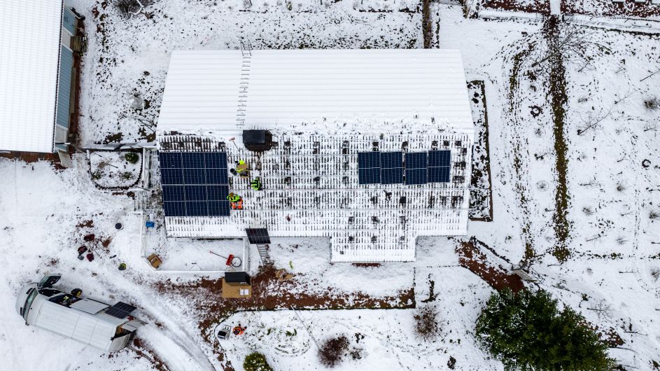 EcoSunWorks solar panels on a snow-covered home roof showing how solar panels work in winter
