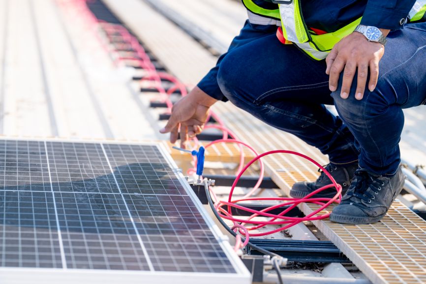 Technician connecting solar panel wiring during installation