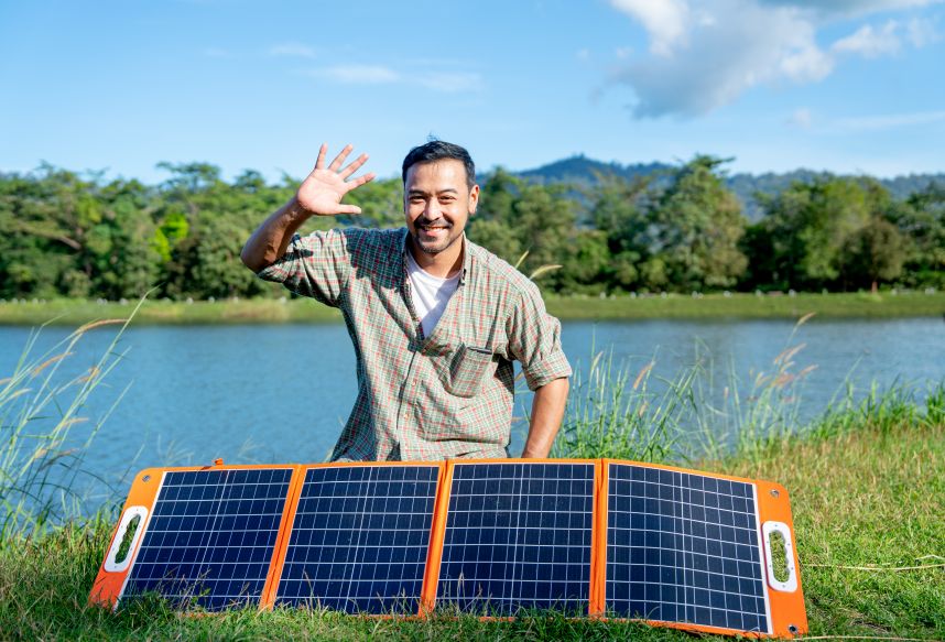 EcoSunWorks customer using portable lightweight solar panels outdoors near a lake, showcasing the flexibility and convenience of Lightweight Solar Panels.